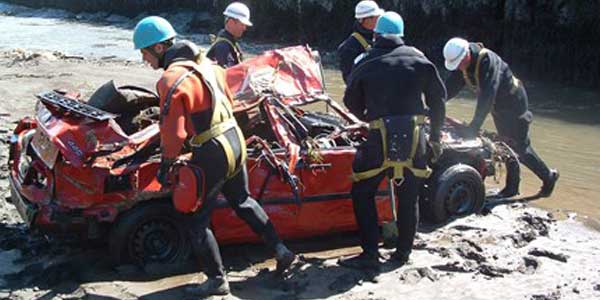 People removing a car from the beach